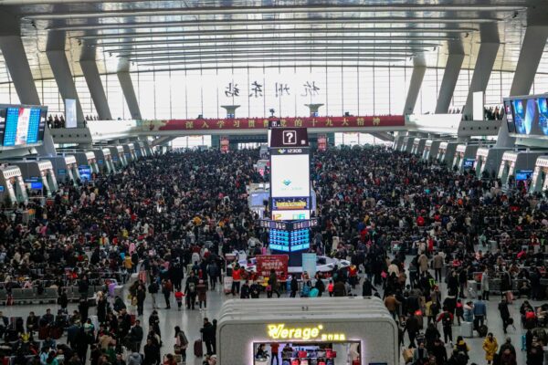 a large crowd of people standing around a train station