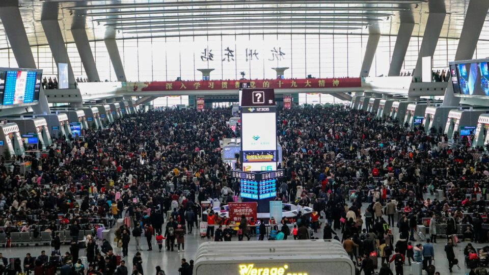 a large crowd of people standing around a train station